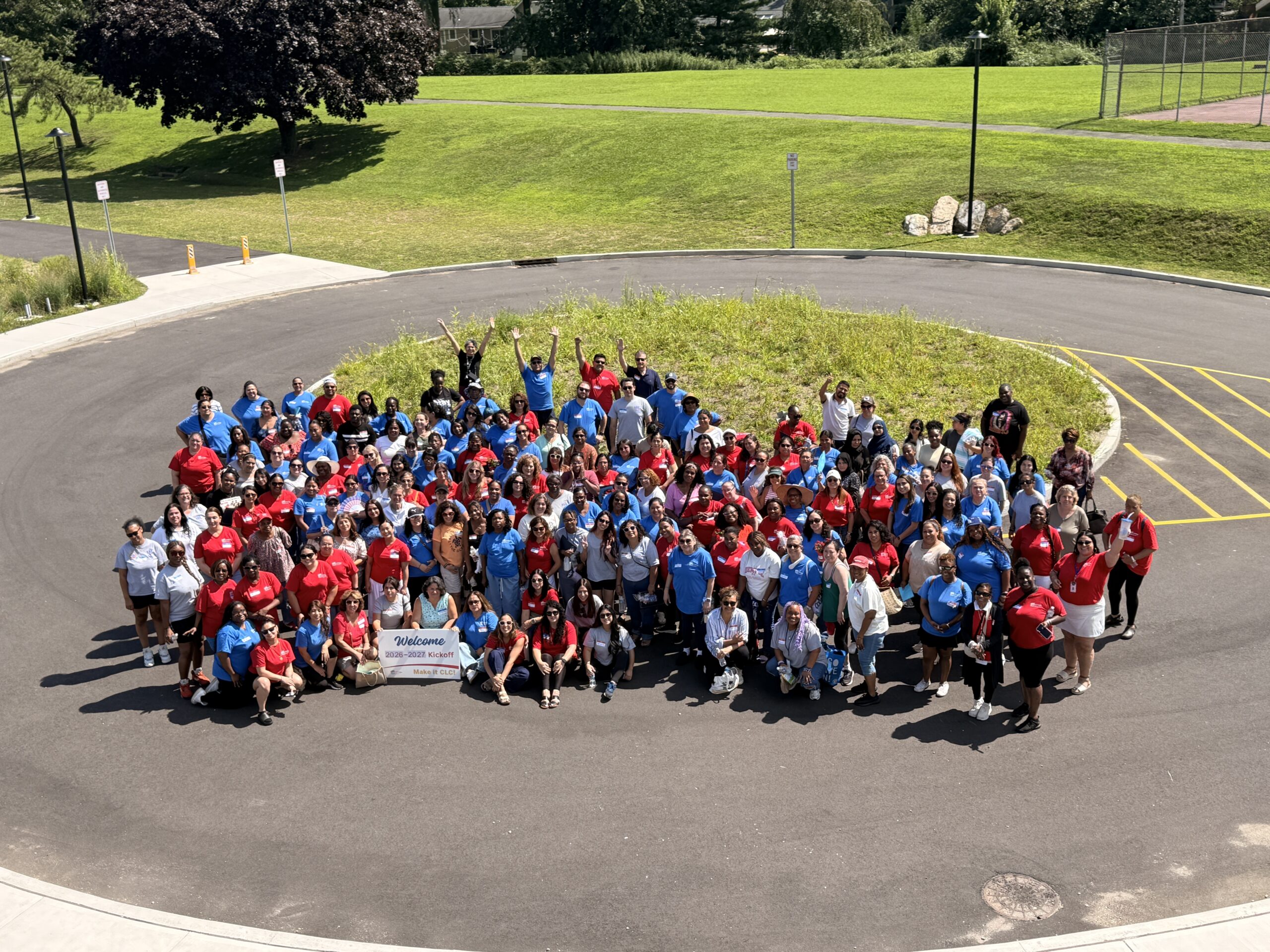 Large group of CLC staff gathered outdoors at SoundWaters for the 2026–2027 All-Staff Kickoff, wearing red and blue shirts and posing together for a group photo.